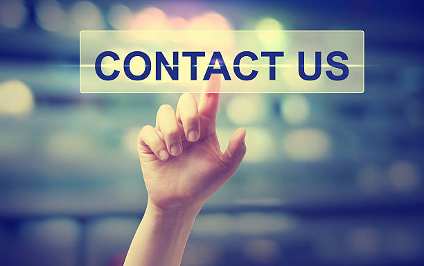 Hand pressing a contact us button on blurred city lights background